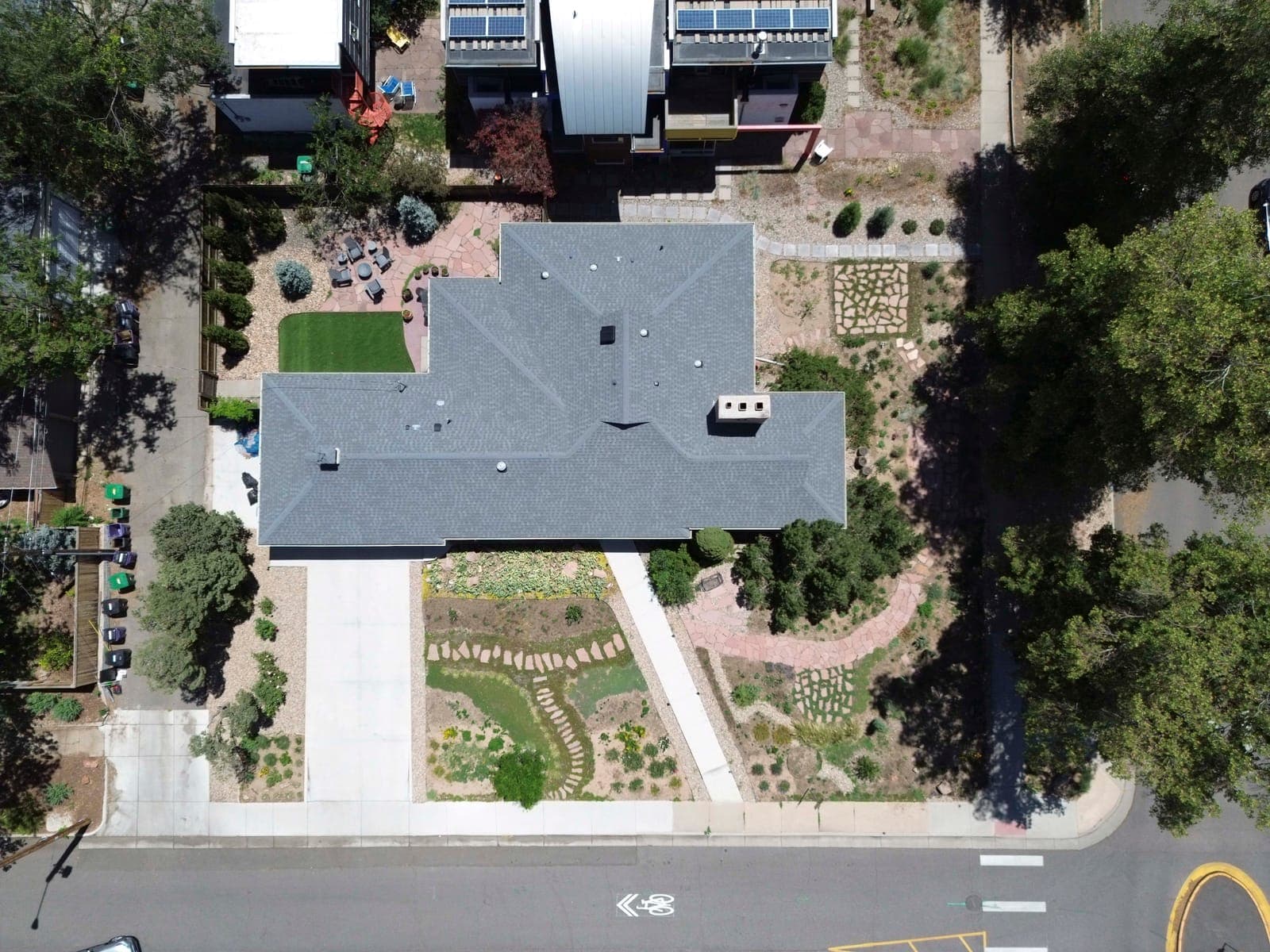 Top-down view of the roofline, driveway, front gardens, and rear patio