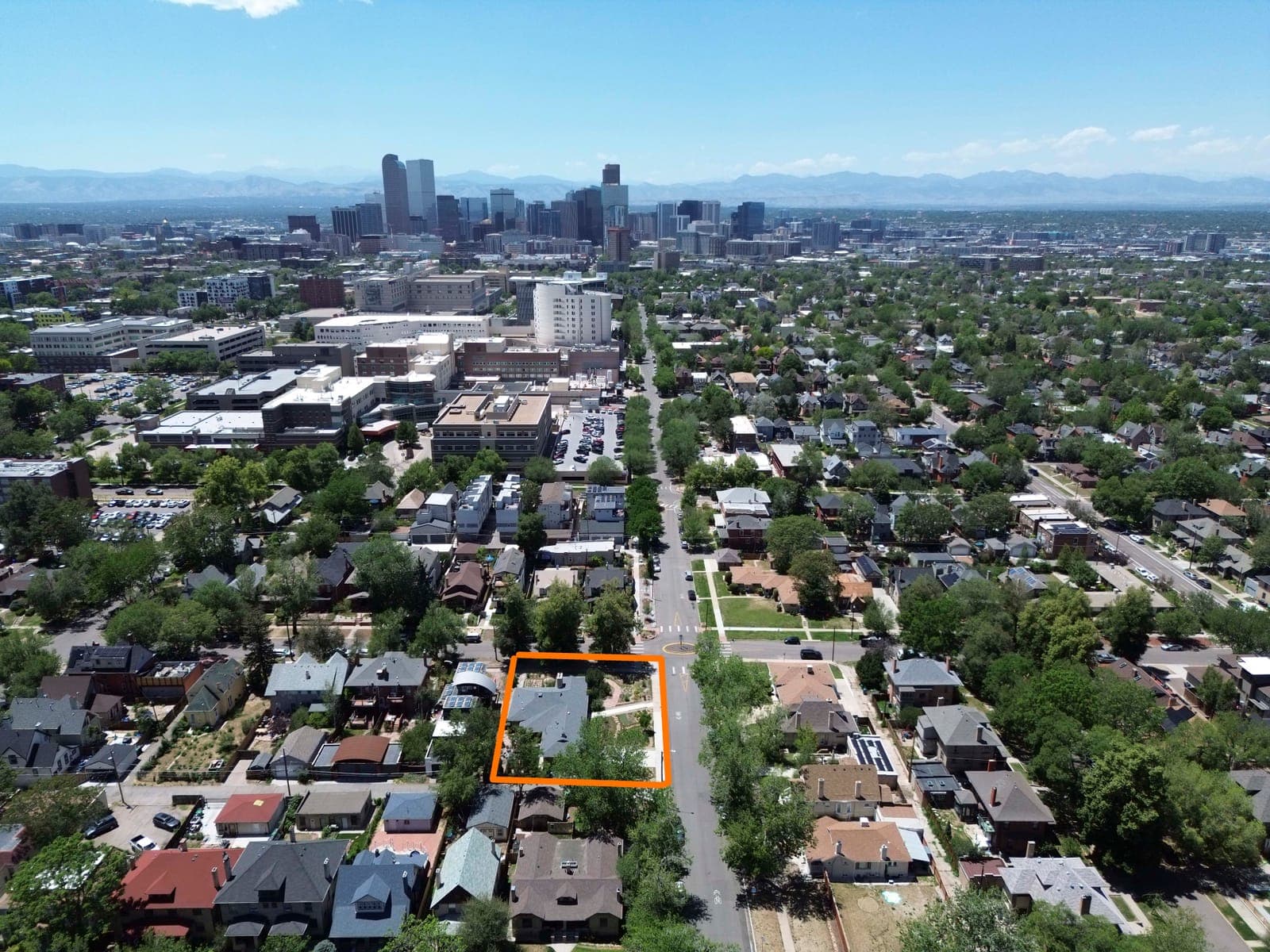 Aerial view of the outlined lot with the downtown Denver skyline and mountains on the horizon