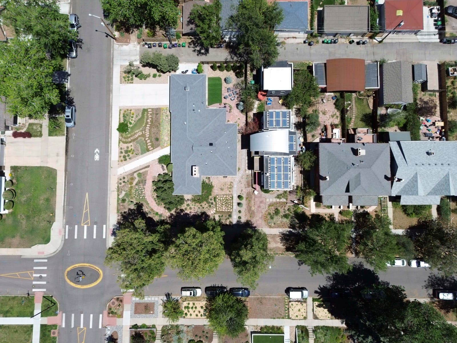 Top-down view of the corner lot, front gardens, and surrounding streetscape