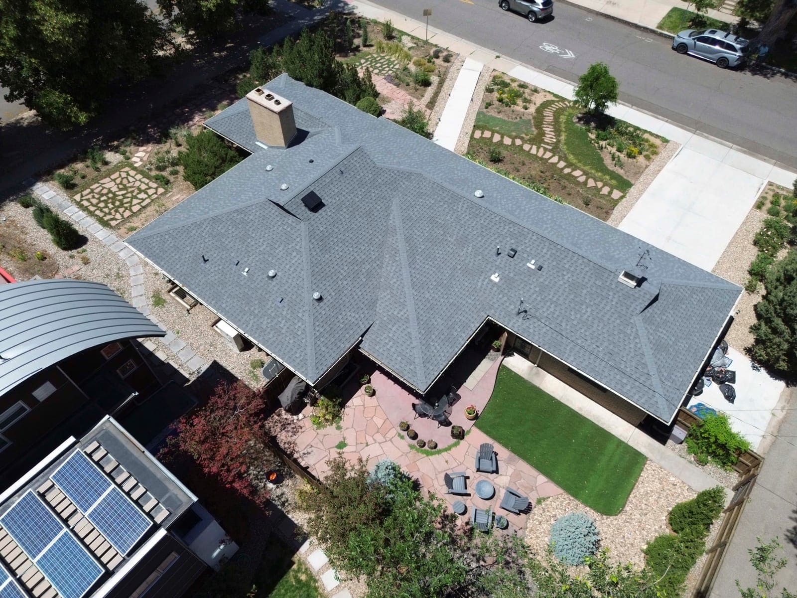 Overhead view of the rear flagstone patio, turf lawn, and perimeter plantings