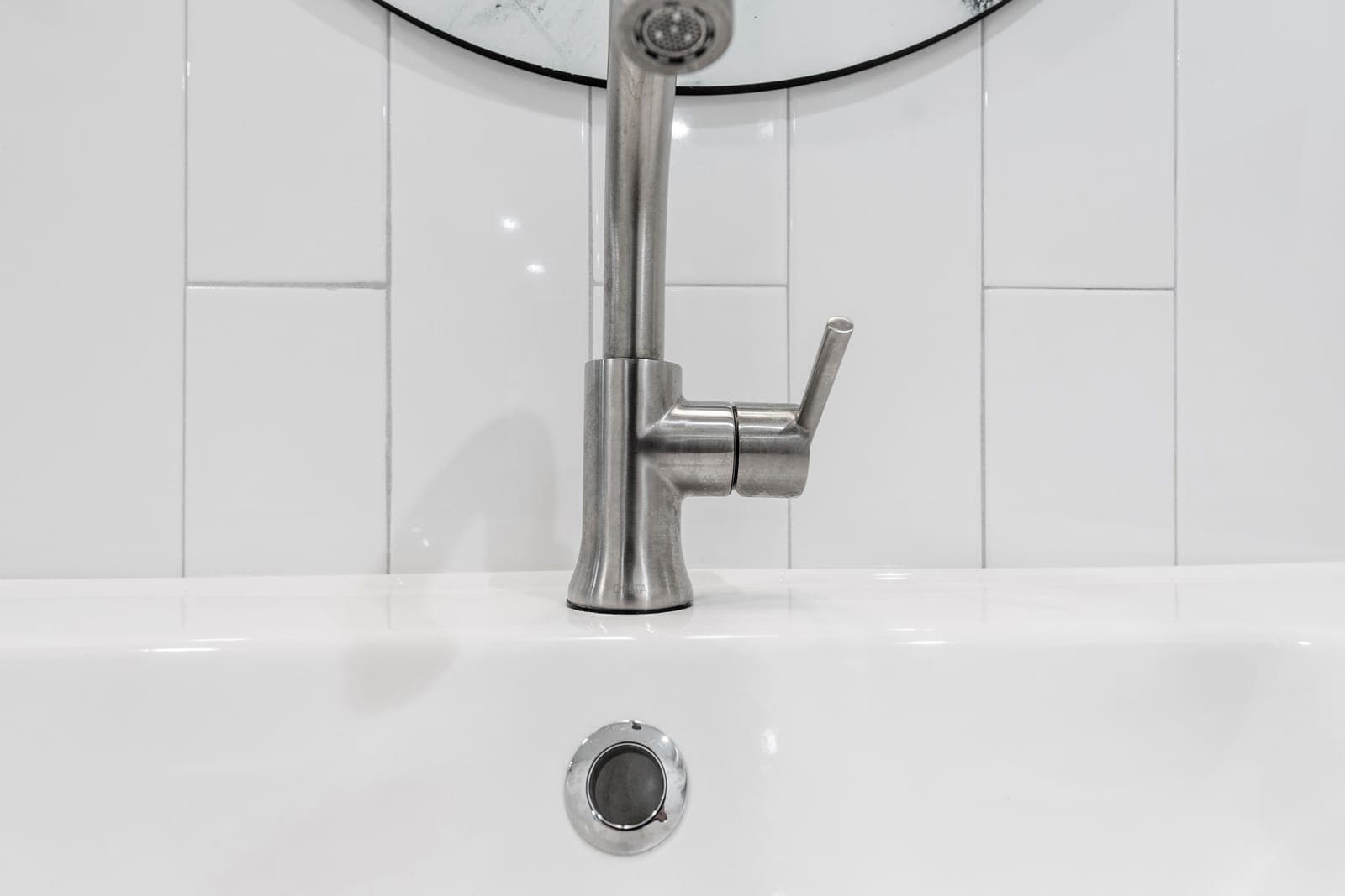 Brushed-nickel single-handle faucet on a white integrated-basin vanity