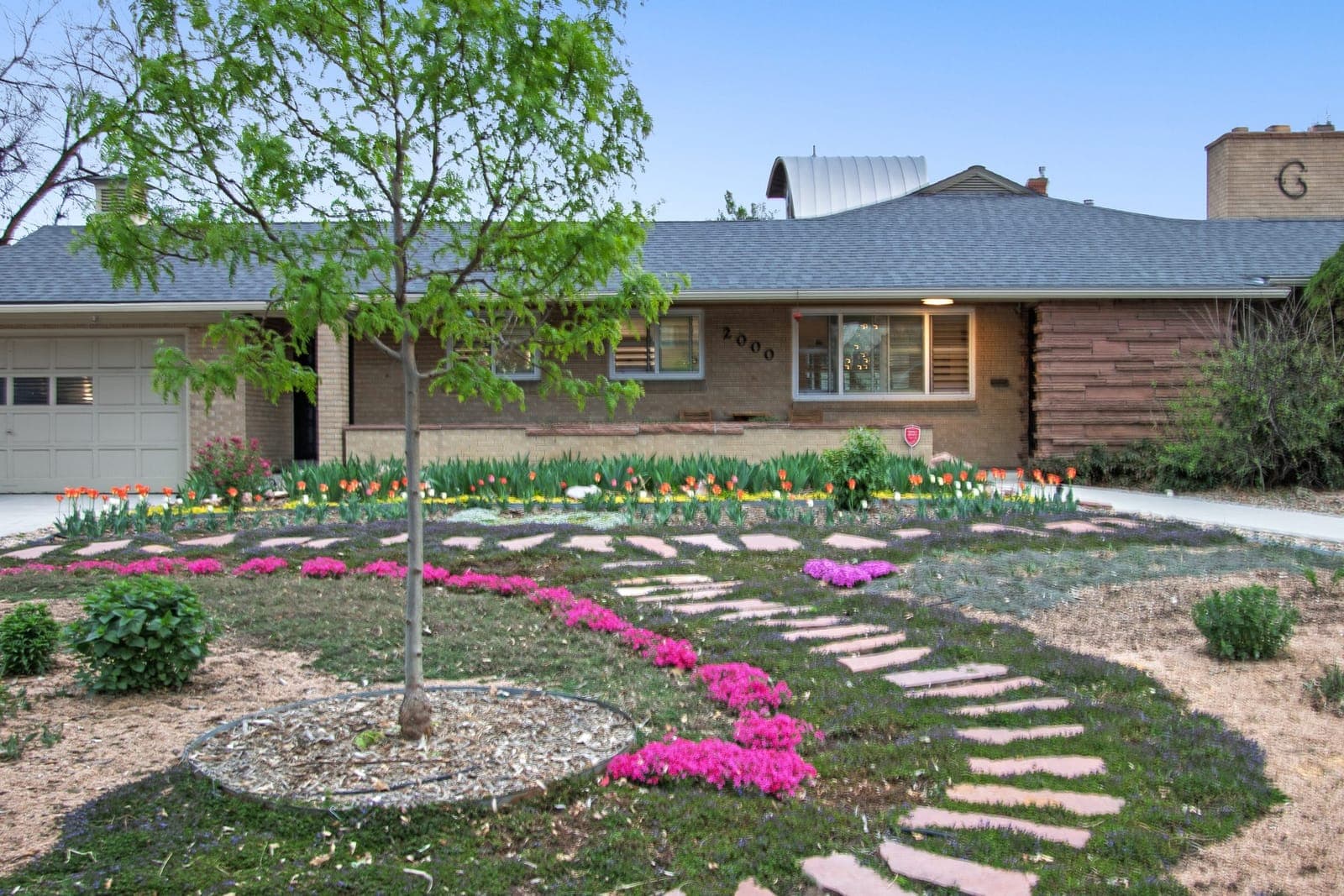 Curved flagstone path with tulips, Turkish veronica, and creeping phlox