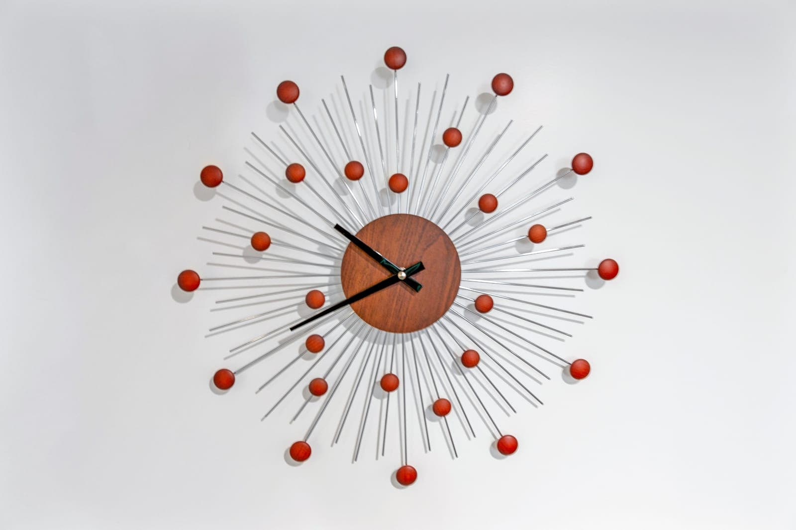 Starburst wall clock with a walnut center and chrome rays