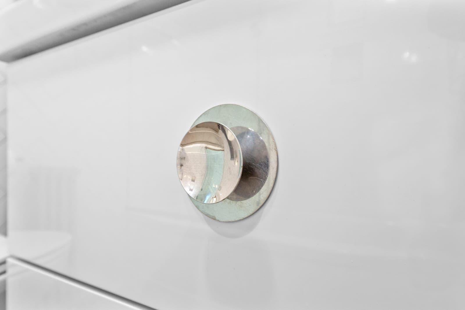 Recessed round pull detail on a white drawer front