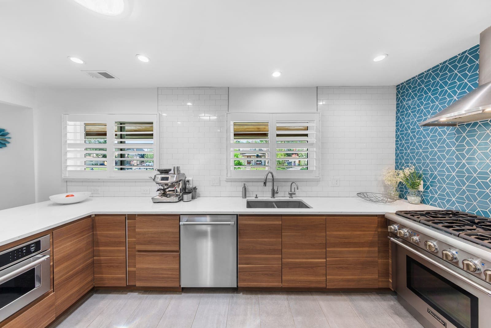 Kitchen work wall with a six-burner gas range and blue geometric tile backsplash