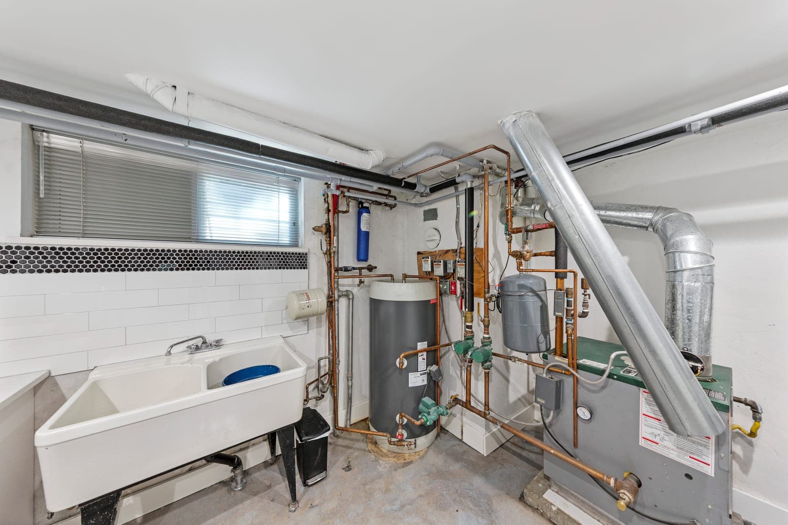 Utility area with a double-basin sink, water heater, and mechanical systems