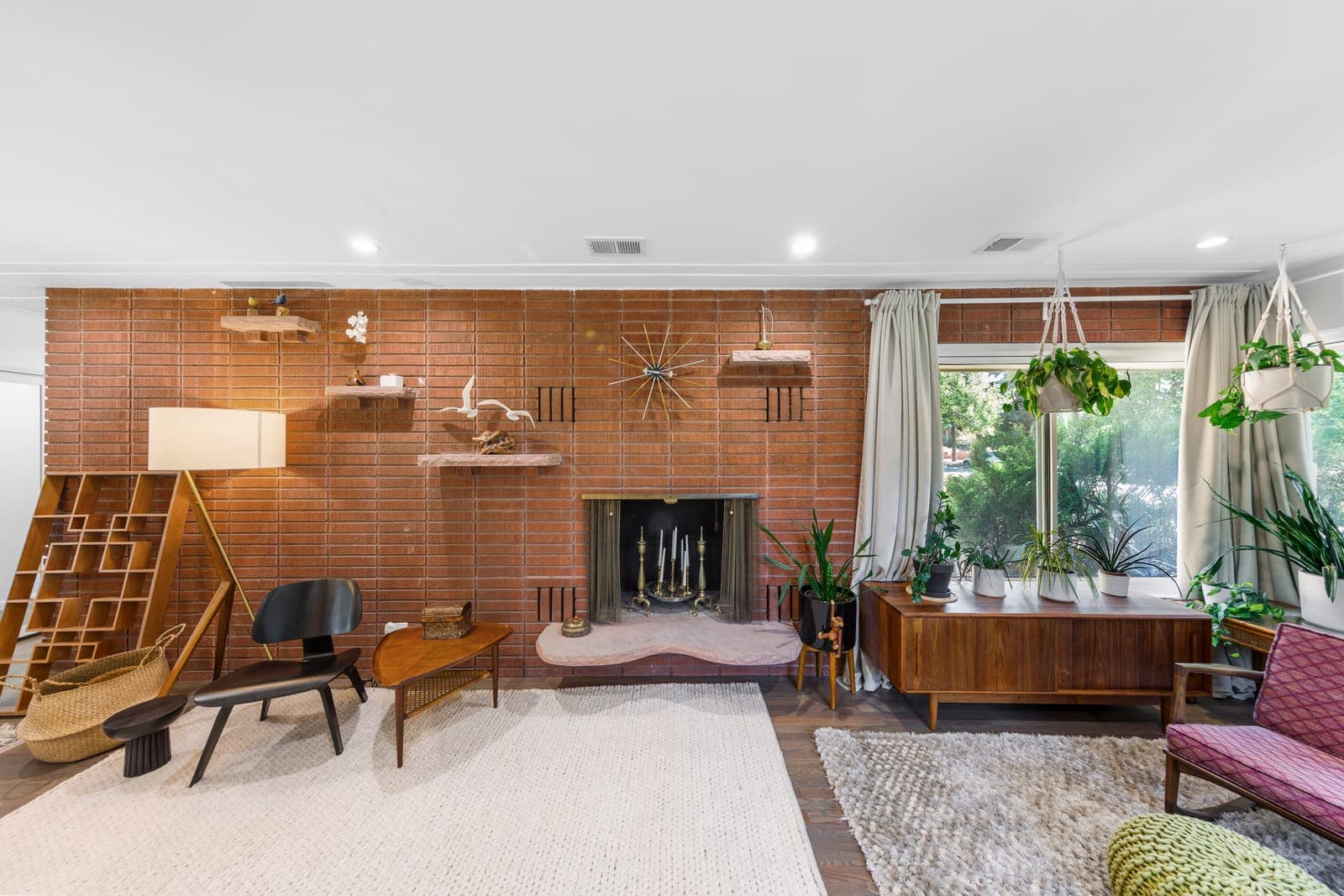 Full brick feature wall with floating stone shelves, starburst clock, and sculpted sandstone hearth