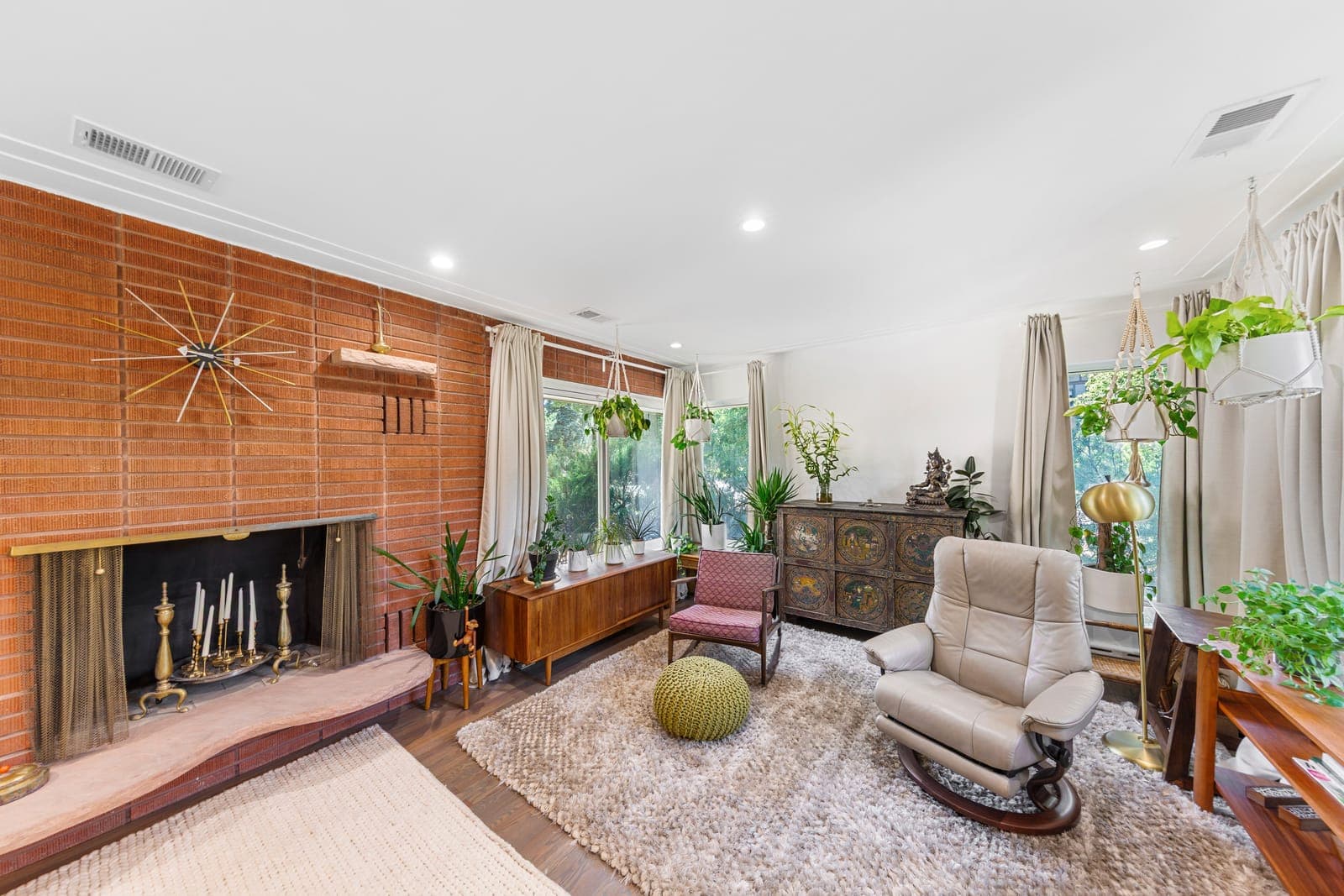 Brick fireplace with a cantilevered sandstone hearth and starburst clock
