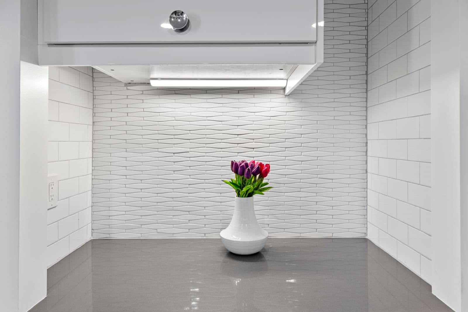 Wet bar niche with dimensional wave tile and under-cabinet lighting