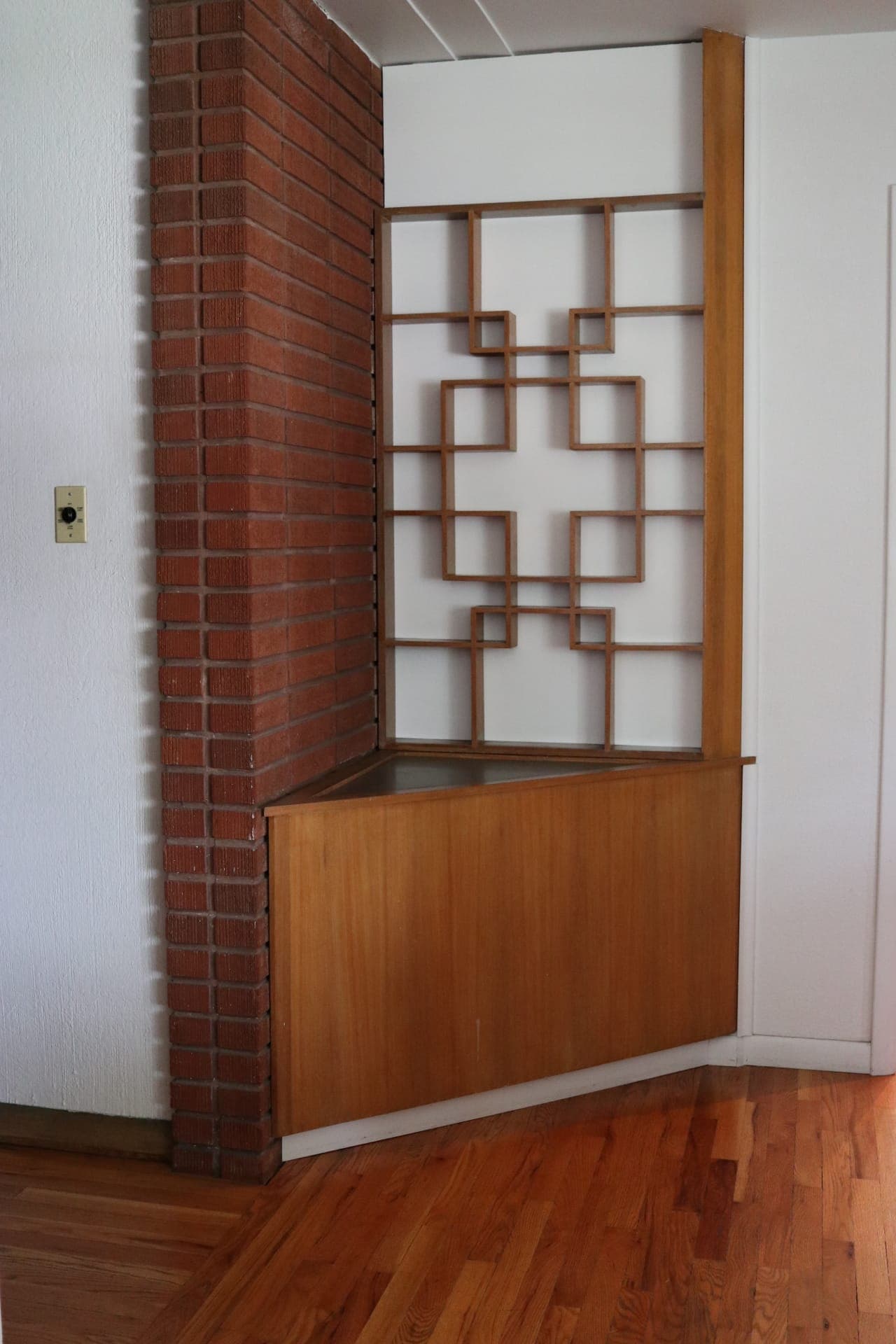 Original wood room-divider screen and brick chimney wall